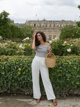 a lady wears a striped off shoulder top with white wide pants